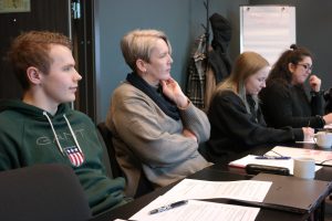 Bildet viser fire personer som sitter ved et møtebord